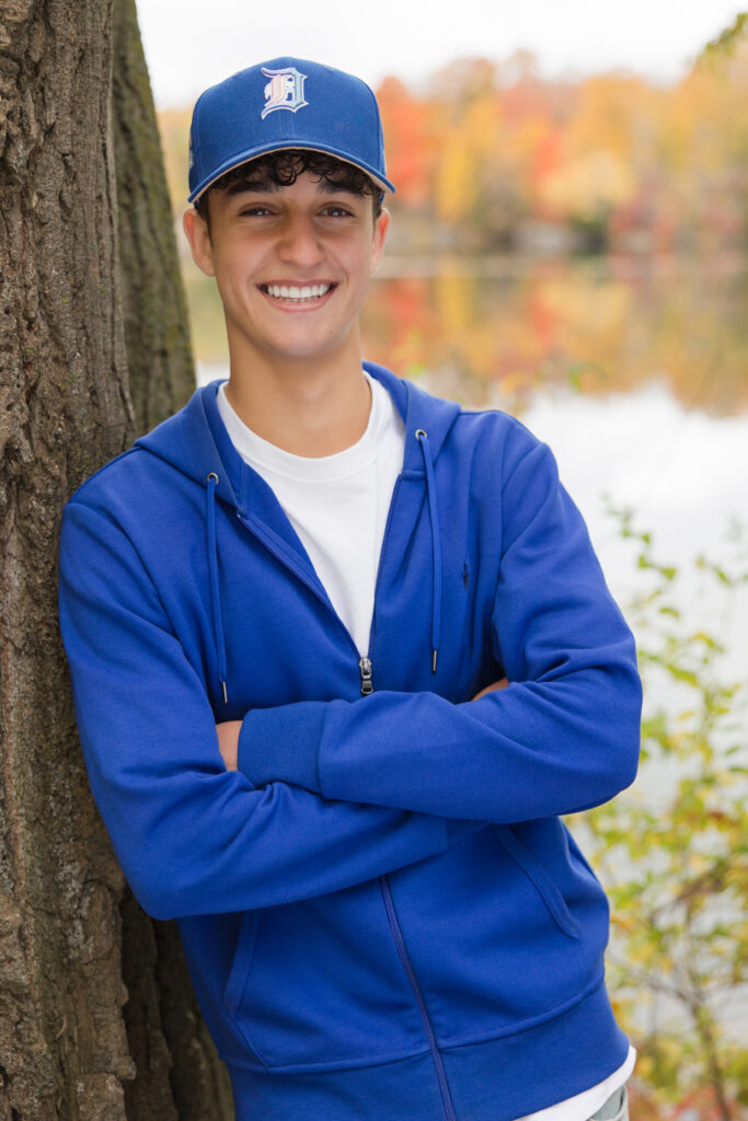 senior guy leaning against a tree