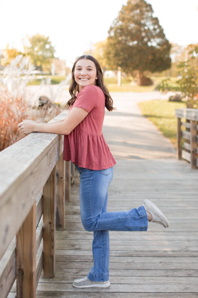 senior girl standing on a bridge