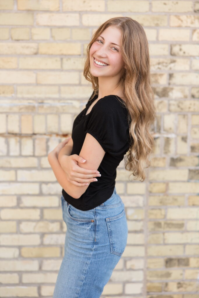 senior girl in front of a wall