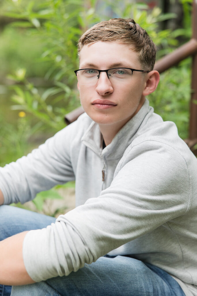 senior guy seated on the stairs looking at the camera
