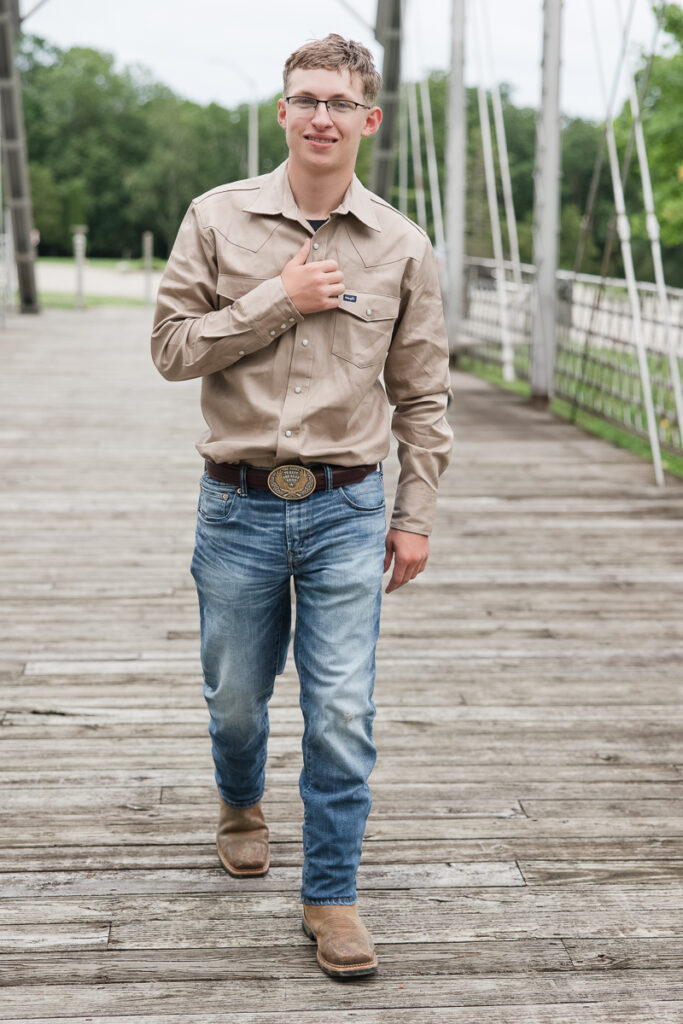 senior guy walking along a bridge smiling at the camera