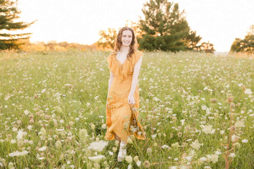 Senior girl walking through a flowery field