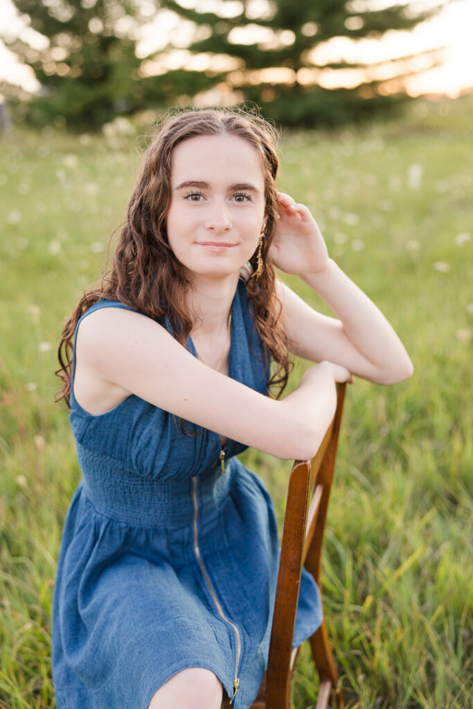 Senior portrait session in Port Washington, Wisconsin of girl seated on a chair in a flowery field