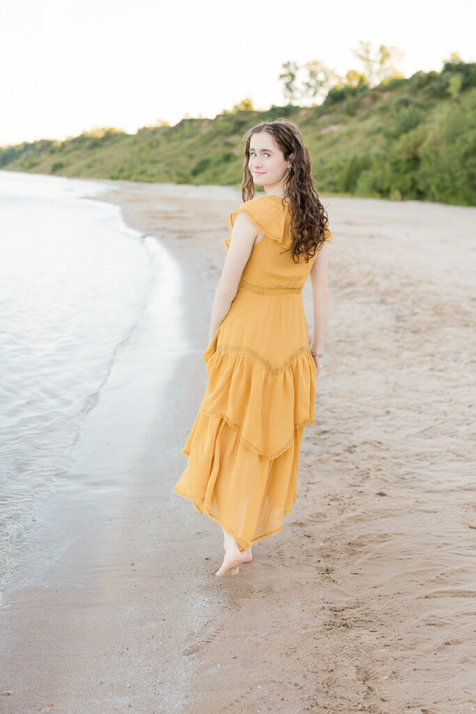 Senior girl walking away from the camera on the beach