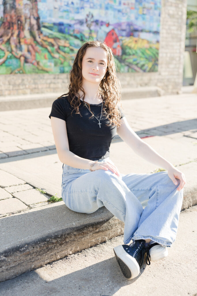 Senior girl sitting on a street curb